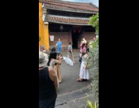 Woman dress with drink poses near building