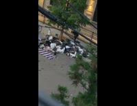 Guy puts trash in white bucket sidewalk 