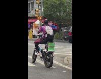 Guy sings while riding bike with mic 
