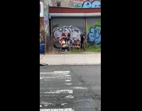 People wearing costumes pose by graffiti wall 