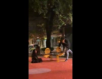 Collab WeirdM - Woman black jacket fell off the yellow spring rider at park when the man stands