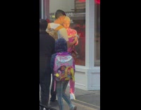 Man in pink outfit has snake in hands