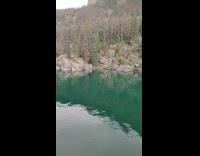 Black shorts guy falls from above lake 