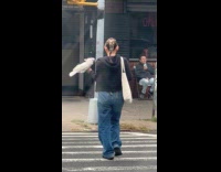 Woman crosses street with a white parrot