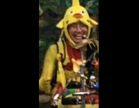 Guy wearing yellow chicken hat plays drums 