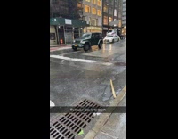 Woman rides citi bike in rain with umbrella