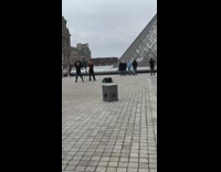Two people practice dance louvre pyramid overcast