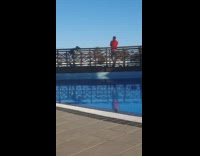 ﻿Man red shirt lean with crossed arms near the pool
