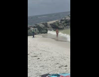 Woman red bikini beside beach jetty photographer
