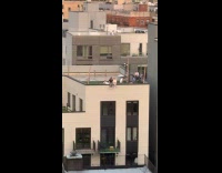 Two ladies sits at edge of rooftop