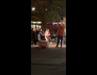 Woman in white outfit dances with people around at the park