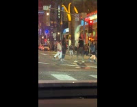 Woman and man films middle of street