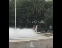 Girl dances in water fountain white shirt