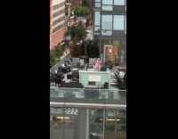 Woman wearing pink dress and wig filming on rooftop
