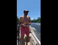 Guy throws beer can to guy on another boat 