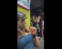 Girl blue shirt Chuck e Cheese mouse turns and looks at her 