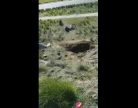 BMX biker jumps over ramp, flips over front wheel and falls into dirt ground