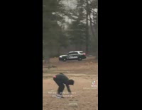 Guy standing in middle of cemetery cop drives by