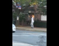 Man wearing white shirt dancing on sidewalk