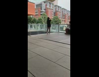 Black shirt girl poses by glass railing 