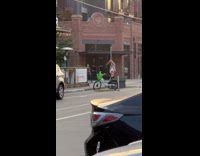 Woman in white crop top pole dances on the sidewalk