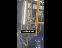 Guy riding bus wears im black yall shirt 
