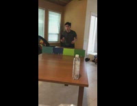 Guy spin backwards hit bottle ping pong