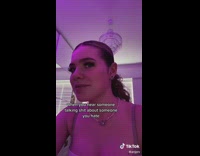 Woman white shirt in purple pink light room slowly turns head