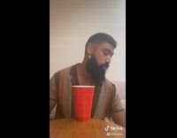 Guy pours vodka red cup jeans pants