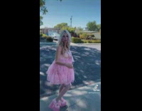 Woman in pink outfit walks down street