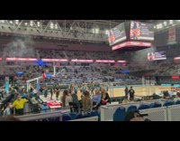 Two blonde girls pose beside basketball court
