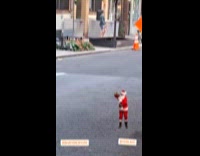 Guy dances to Christmas song on sidewalk