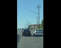 Person driving car grabs a drink from car next to them 
