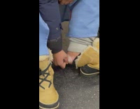 Guy rubs foot on subway brown boots