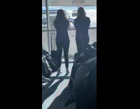 Two girls dance at airport lobby