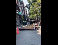 Firefighters clearing fallen roofing on sidewalk