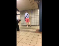 Man pink shorts sings quietly and dances while listening to music on earphones