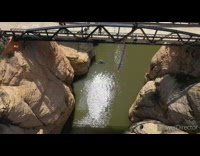 Guy backflips bridge arch green lake water 