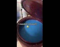 Woman opens red can with blue paint 