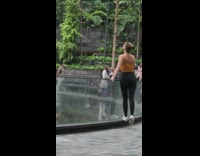 Woman yellow top lean on glass water fountain