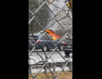 Car burn on the road rain fence