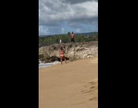 Shirtless muscled man sunglasses stand rock beach