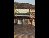 Girl white dress hut roof lake sunset