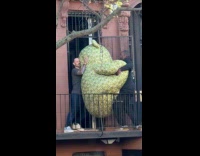 Two guys carry large teddy bear through door