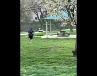 Dad in red hat chasing after kids driving off in small electric jeep 
