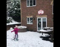 Little girl shoots basketball backwards