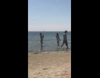 guy takes video of girl in white outfit beach
