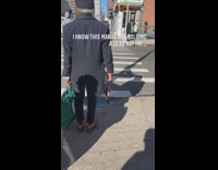 Guy on crosswalk holding rat like object