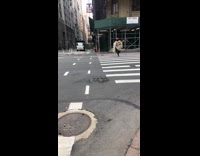 Person wearing white poncho strums guitar crosswalk 
