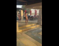 Woman bikini pose beside artificial waterfalls resort